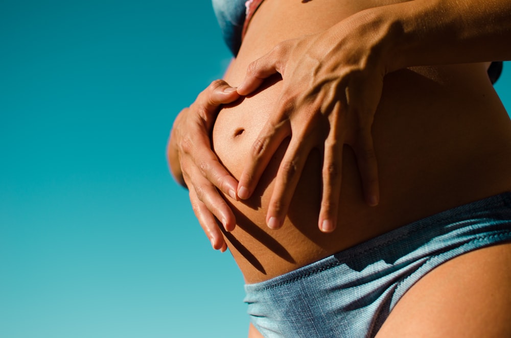 closeup photography of pregnant woman wearing blue panty