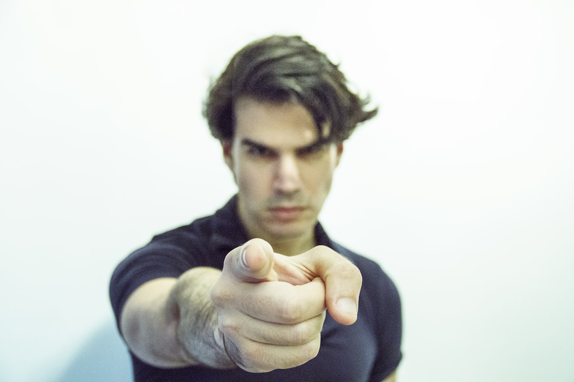 Angry man pointing right forefinger at you