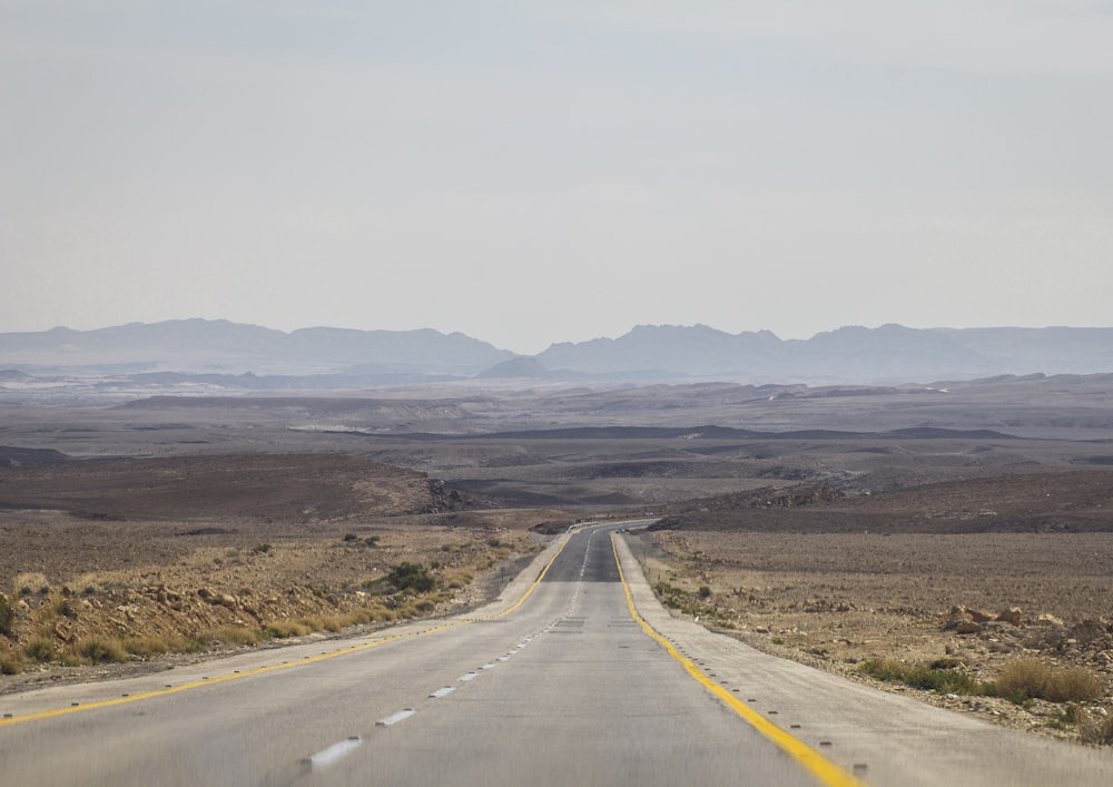 gray asphalt road towards open valley t