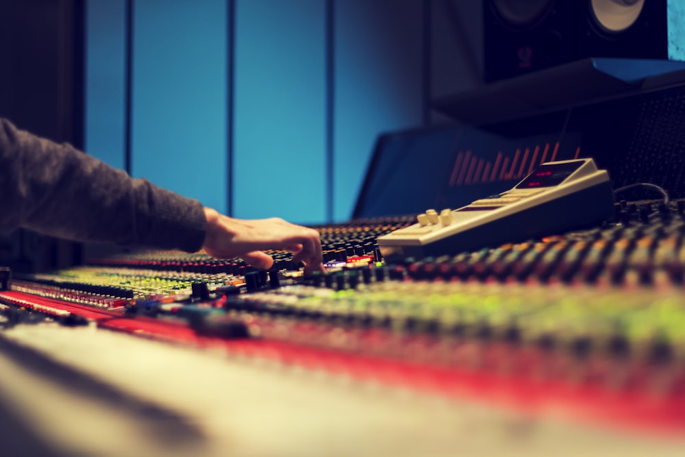 closeup photography of man operating audio mixer