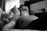 grayscale photo of man laying on bed