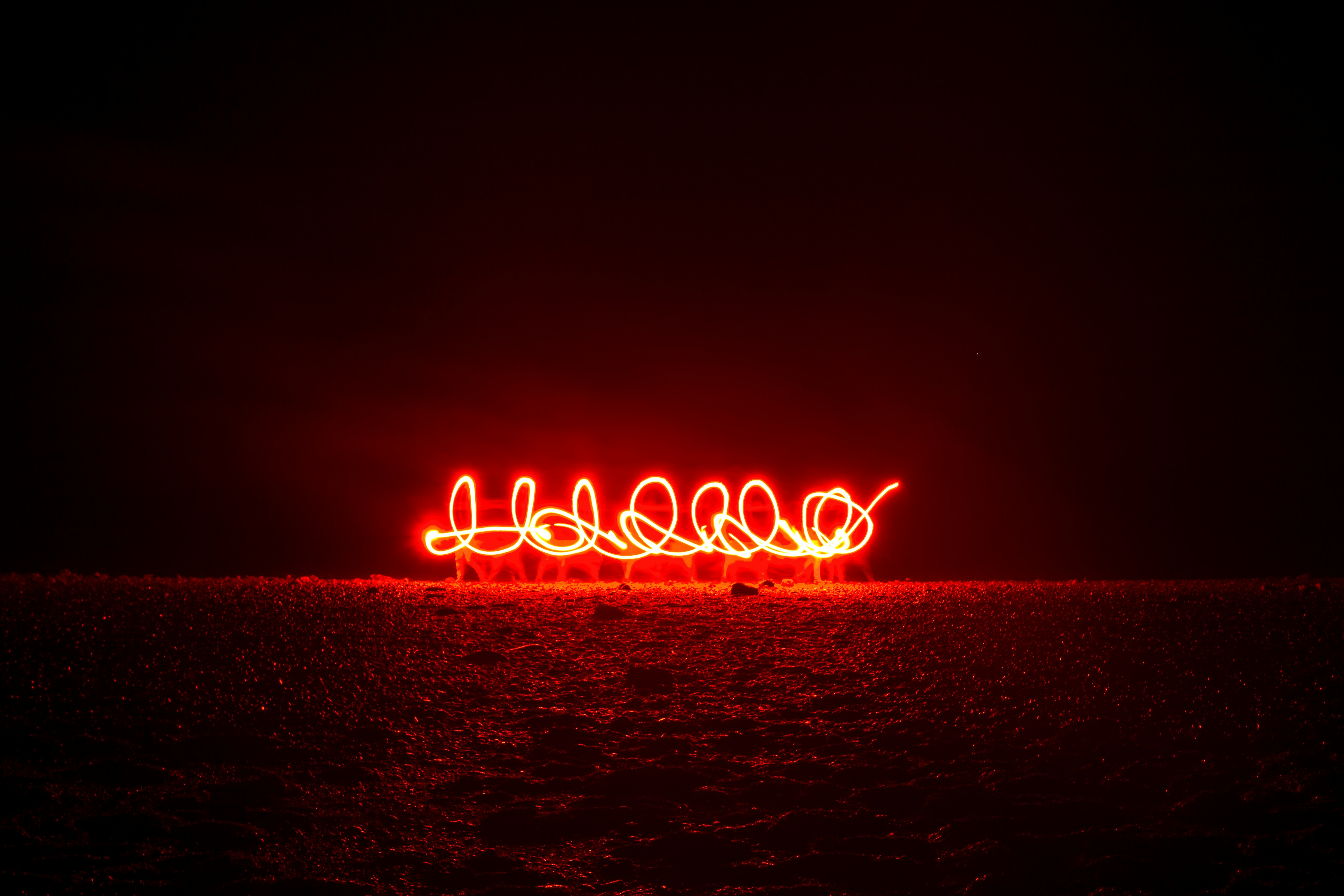 red light near ocean during night time