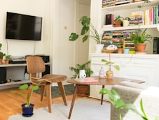 brown wooden table and chair beside bookshelf