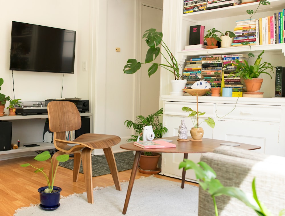 Mesa y silla de madera marrón al lado de la estantería