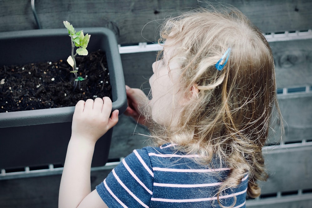 girl holding onto a plastic pot