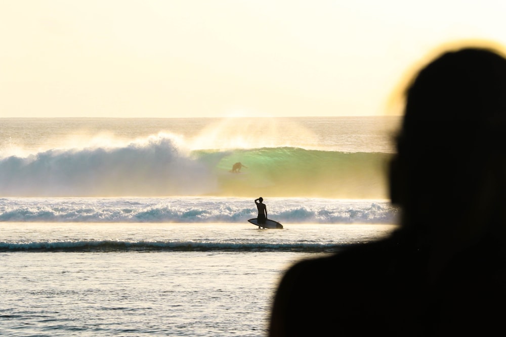 person holding white surfboard