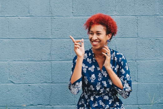 woman smiling while pointing on her right side