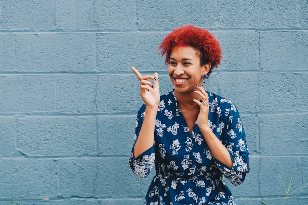 woman smiling while pointing on her right side