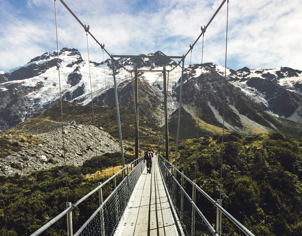 person walking on hanging bridge during daytime