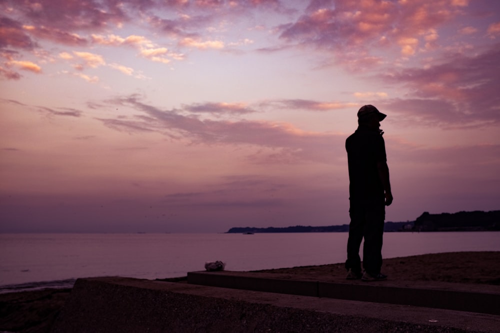 silhouette of man standing on seashore