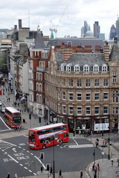 aerial photography of buses on road between European styled building