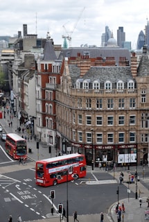 aerial photography of buses on road between European styled building