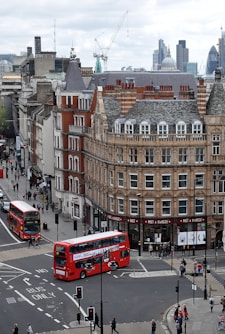 aerial photography of buses on road between European styled building