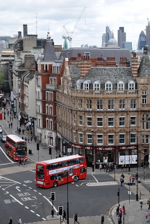 aerial photography of buses on road between European styled building