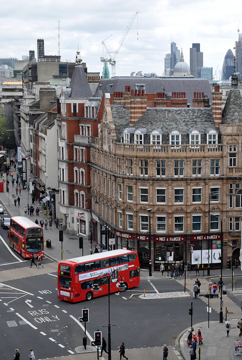 aerial photography of buses on road between European styled building