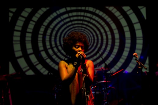 A professional singer performing on stage at a corporate event with ambient lighting.