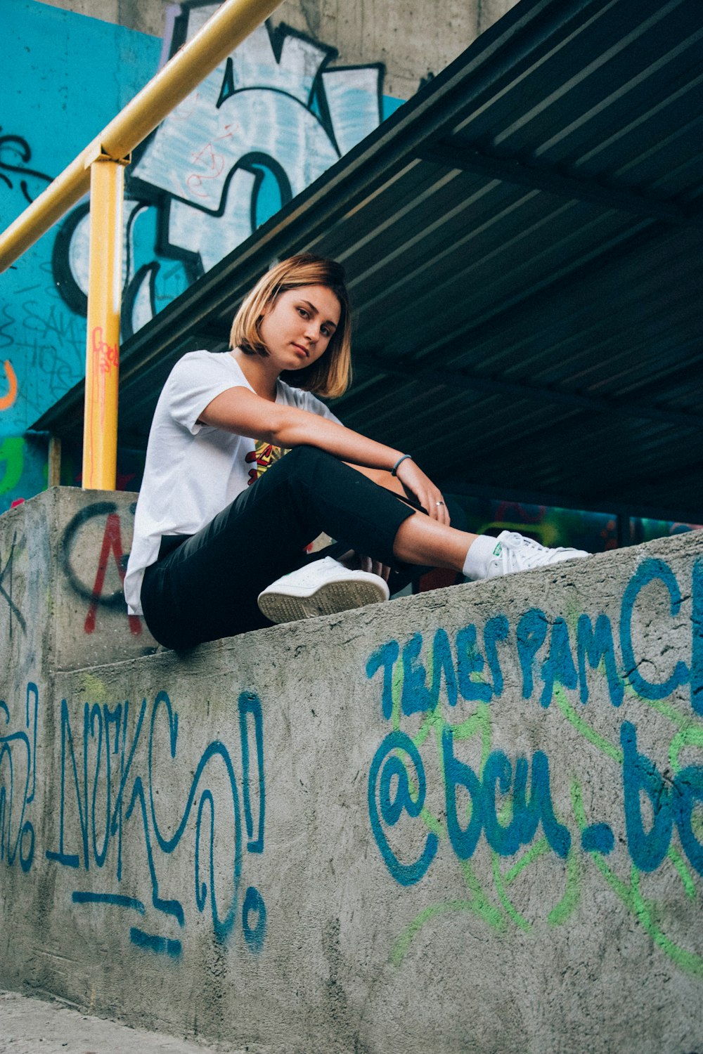 woman sitting on gray concrete pavement