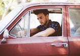 man in red car