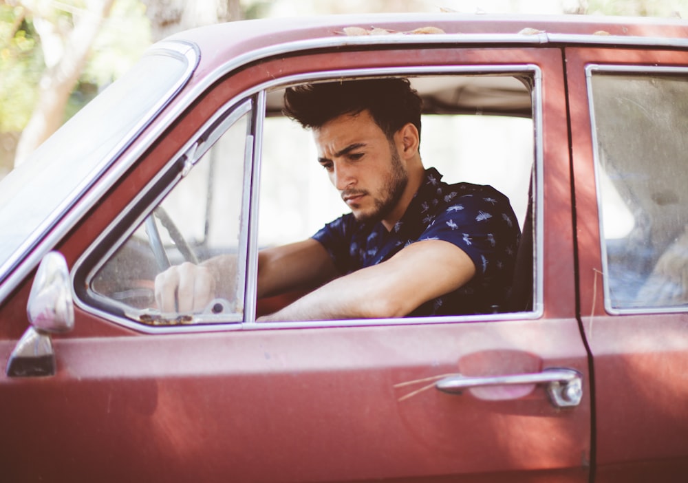 man in red car