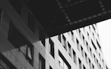 Black and white photo of a sleek commercial building facade with gradient shadows.