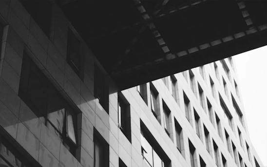 Black and white photo of a modern building facade with soft shadows and gradient lighting.