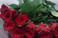 Close-up of a luxurious red rose bridal bouquet with gold ribbon detail.