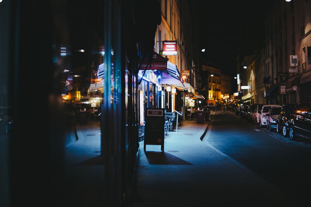 cars parked in front of stores during nighttime