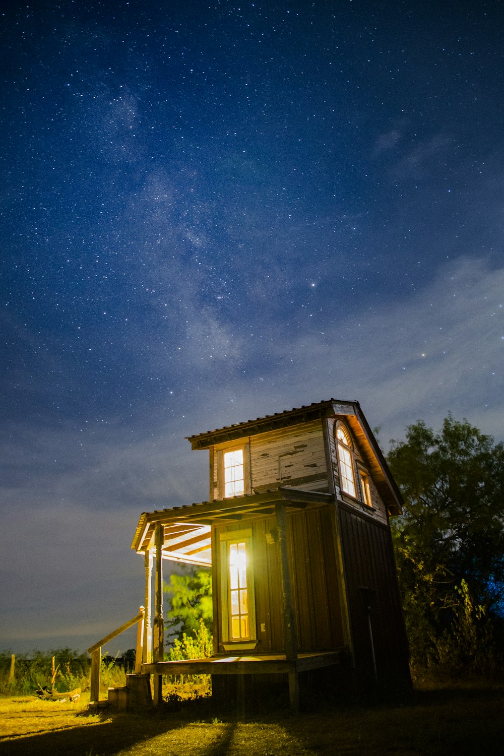 casa de madera marrón al lado de la hoja verde en la noche