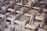 Various powdered food additives displayed in small transparent containers on a wooden table.