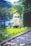 An elderly person with short blond hair is sitting by a canal or river, surrounded by greenery and trees. The setting appears to be a park or a garden with a building in the background. Sunlight filters through the trees, creating a serene and peaceful atmosphere.