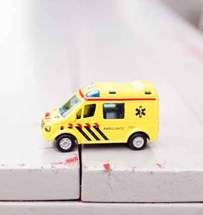 yellow car toy on white surface