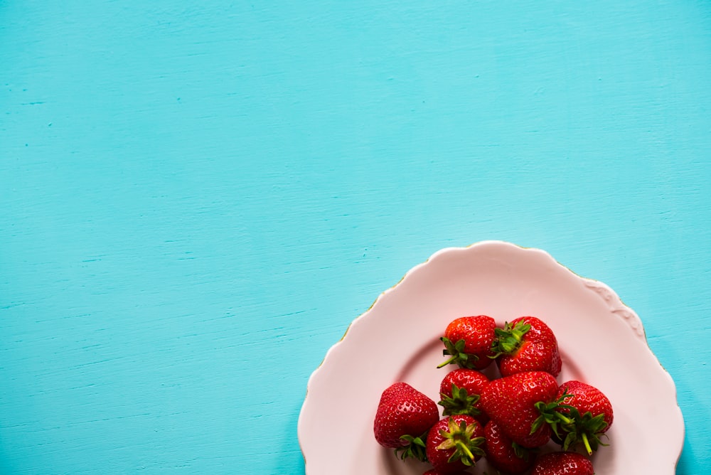 flat lay photography of bunch of strawberries on white plate