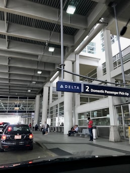 A happy customer picking up a rental car at a busy airport terminal.