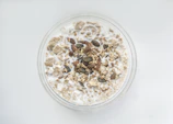 A bowl of wholesome dalia porridge topped with nuts and seeds.