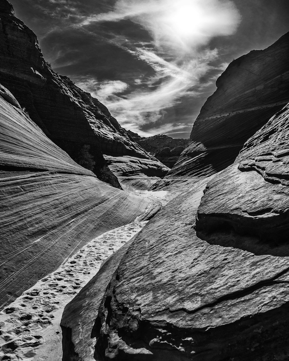 Darkened view from the bottom of a rocky canyon.