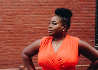 woman standing in front of red brick wall