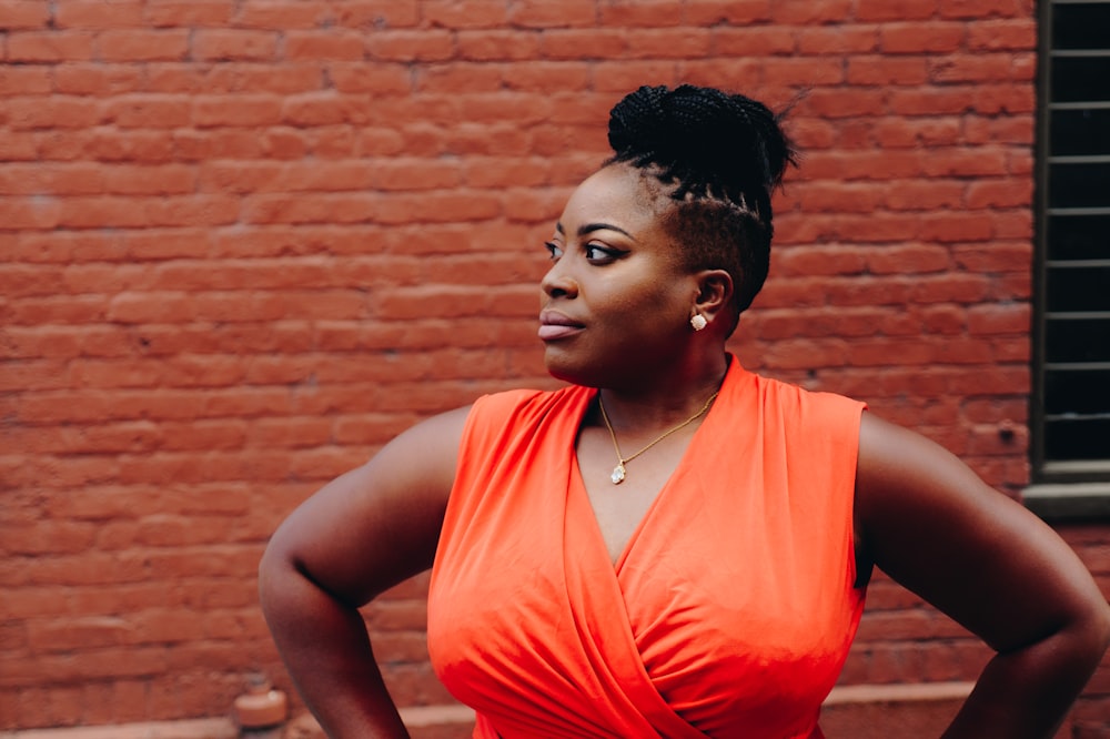 woman standing in front of red brick wall