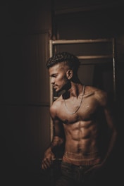 A powerful image of the founder mid-workout, muscles defined and focused expression, set against a sleek gym backdrop with electric blue lighting accents.