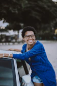 A lifestyle shot of a smiling influencer showcasing sustainable EV gear outdoors.