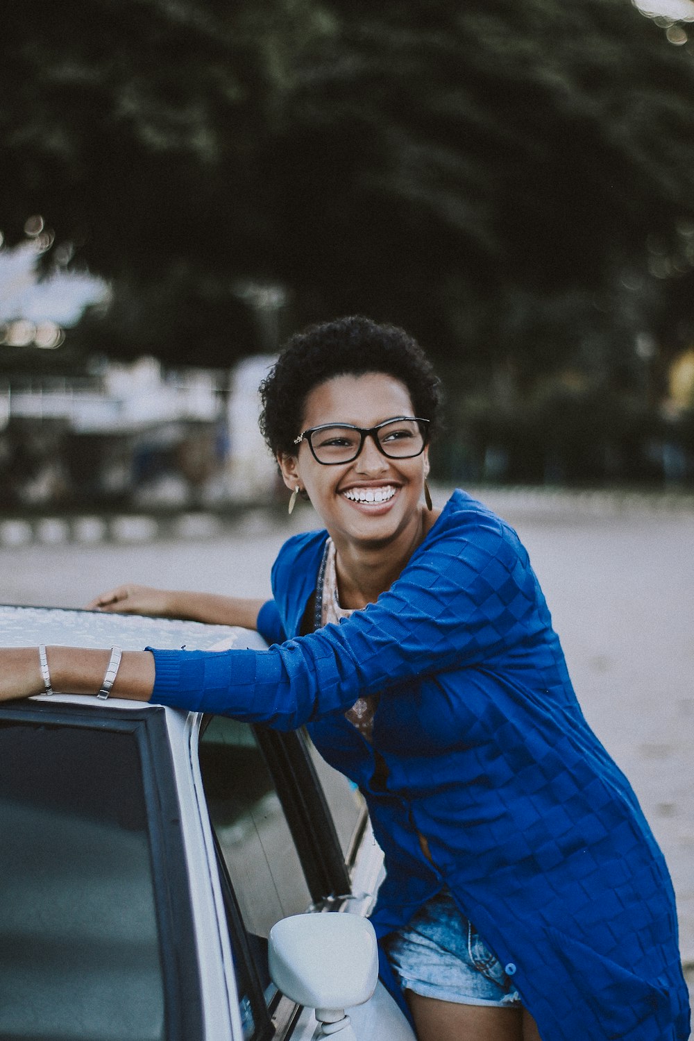 woman beside white vehicle during daytime