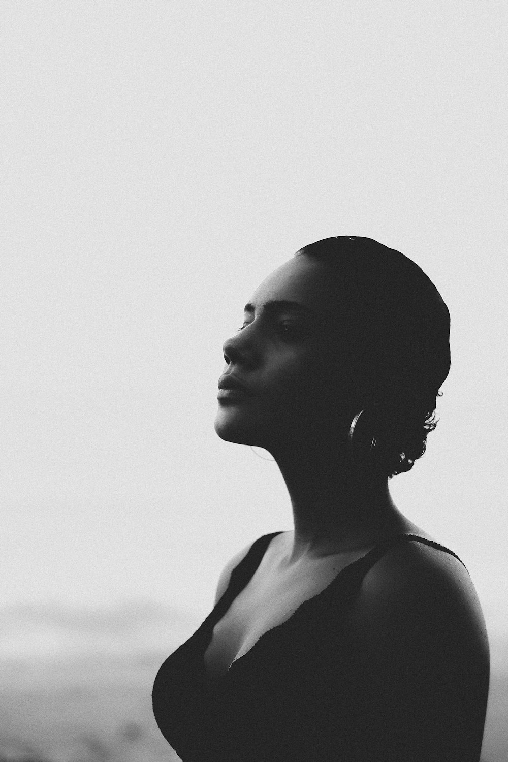 black and white beautiful short haired woman in wearing black sleeveless low cut dress