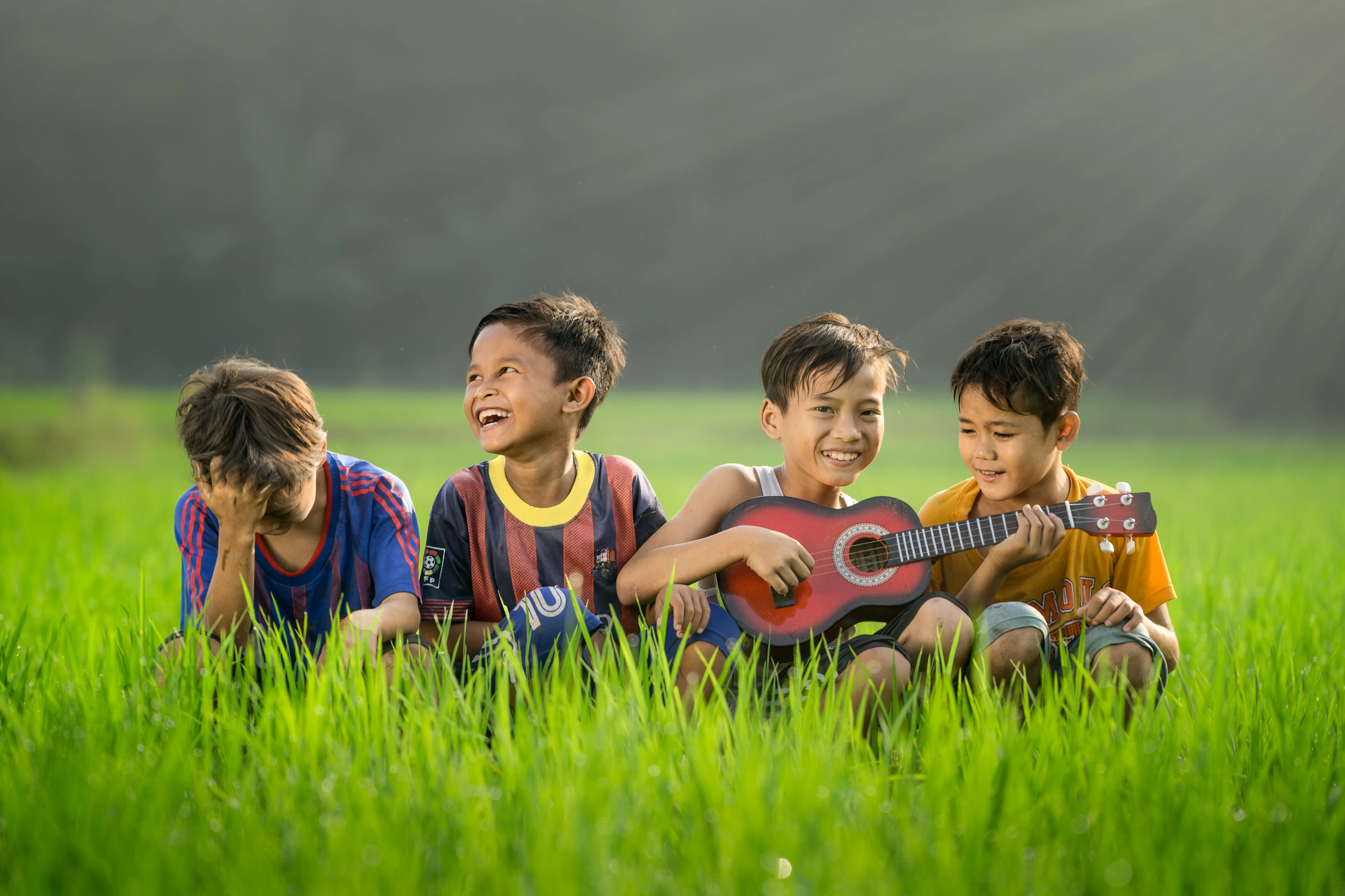 Niños riendo sentados en la grama
