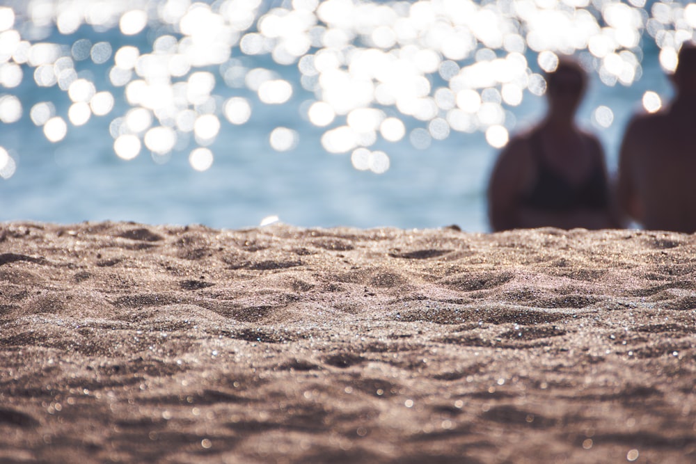 Person, die tagsüber auf dem Sand spazieren geht