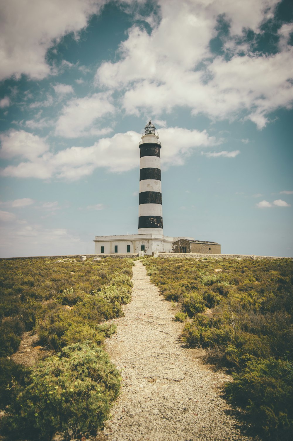 Phare sous les cumulus et ciel bleu calme