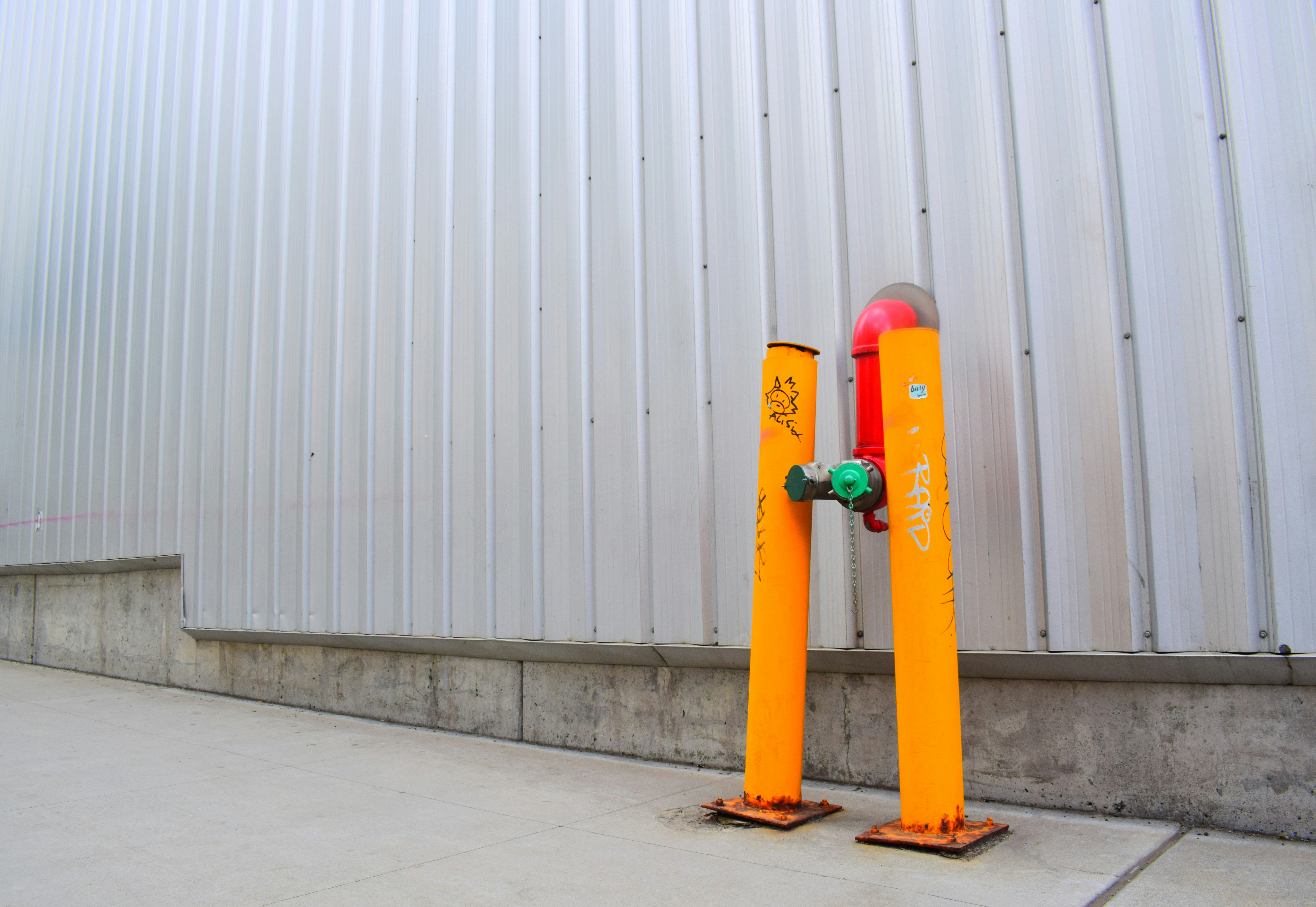blue and yellow skateboard leaning on white wall