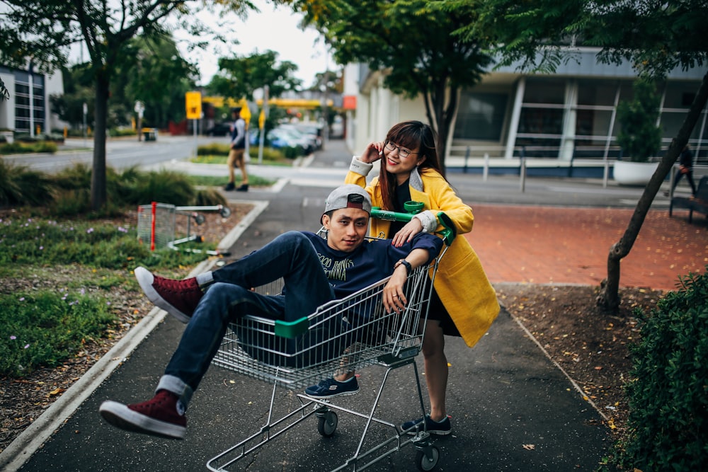 man sitting in shopping cart during daytime