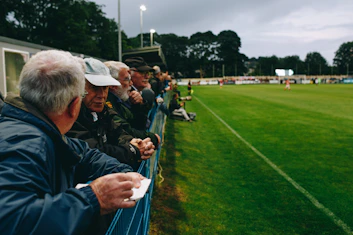 group of men standing on railings during daytime