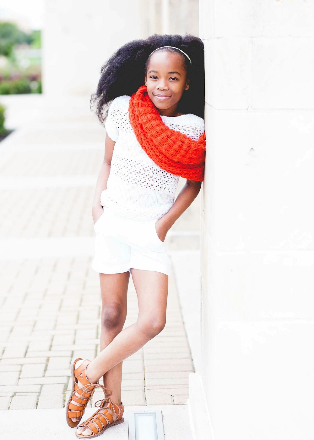 smiling girl in white shirt and shorts wearing red scarf during daytime