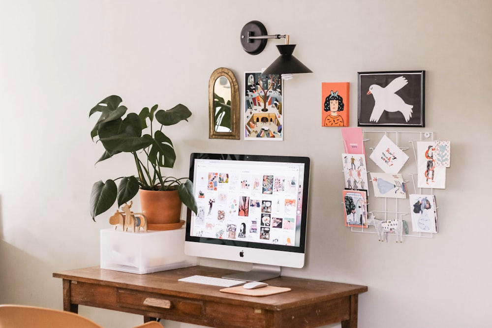 iMac prateado na mesa de madeira