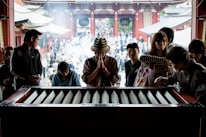 Close-up of hands making a donation at a temple altar.